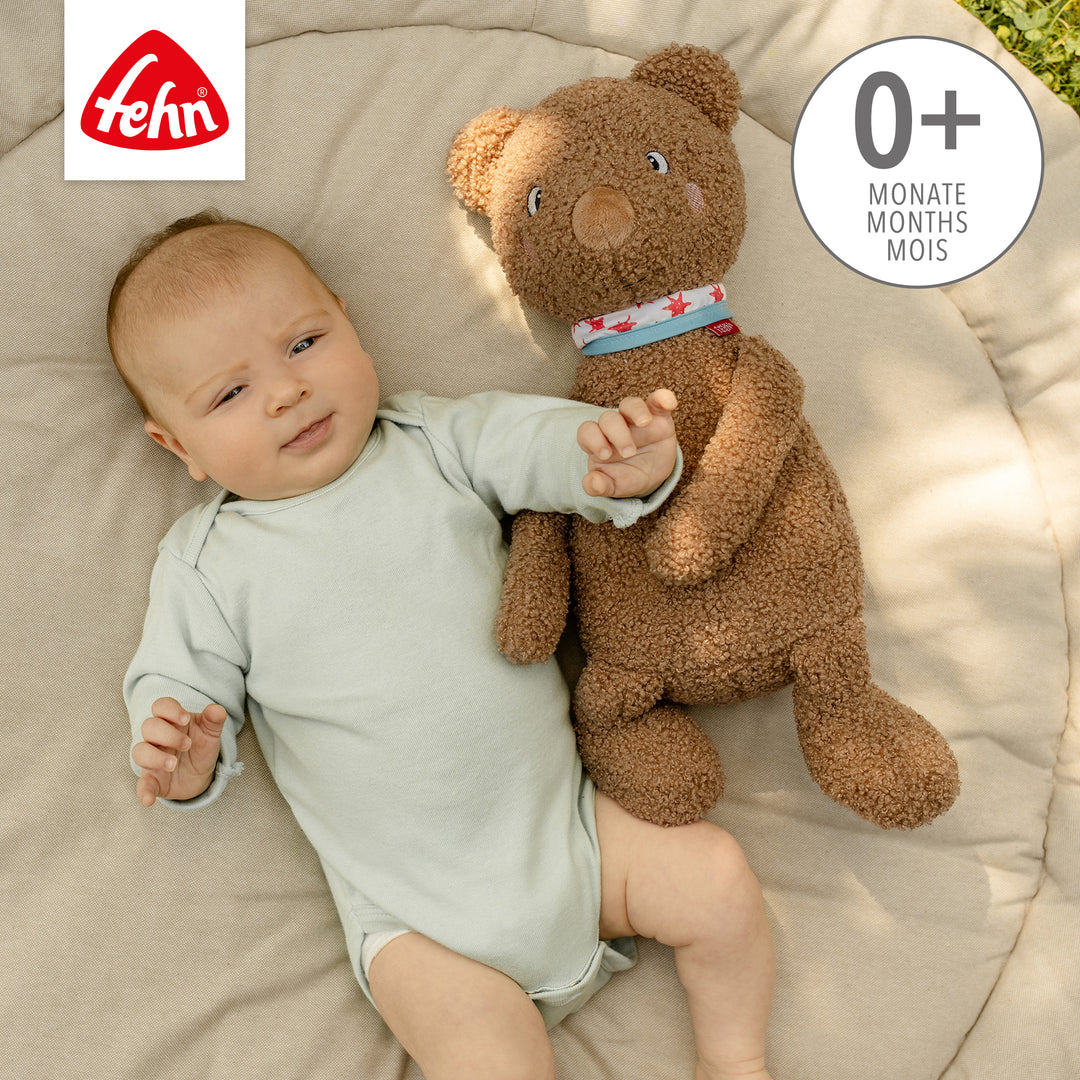 Baby liegt neben Baby Kuscheltier Bär XL aus weichem Curly-Stoff