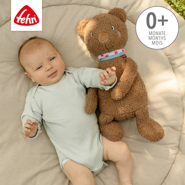 Baby liegt neben Baby Kuscheltier Bär XL aus weichem Curly-Stoff
