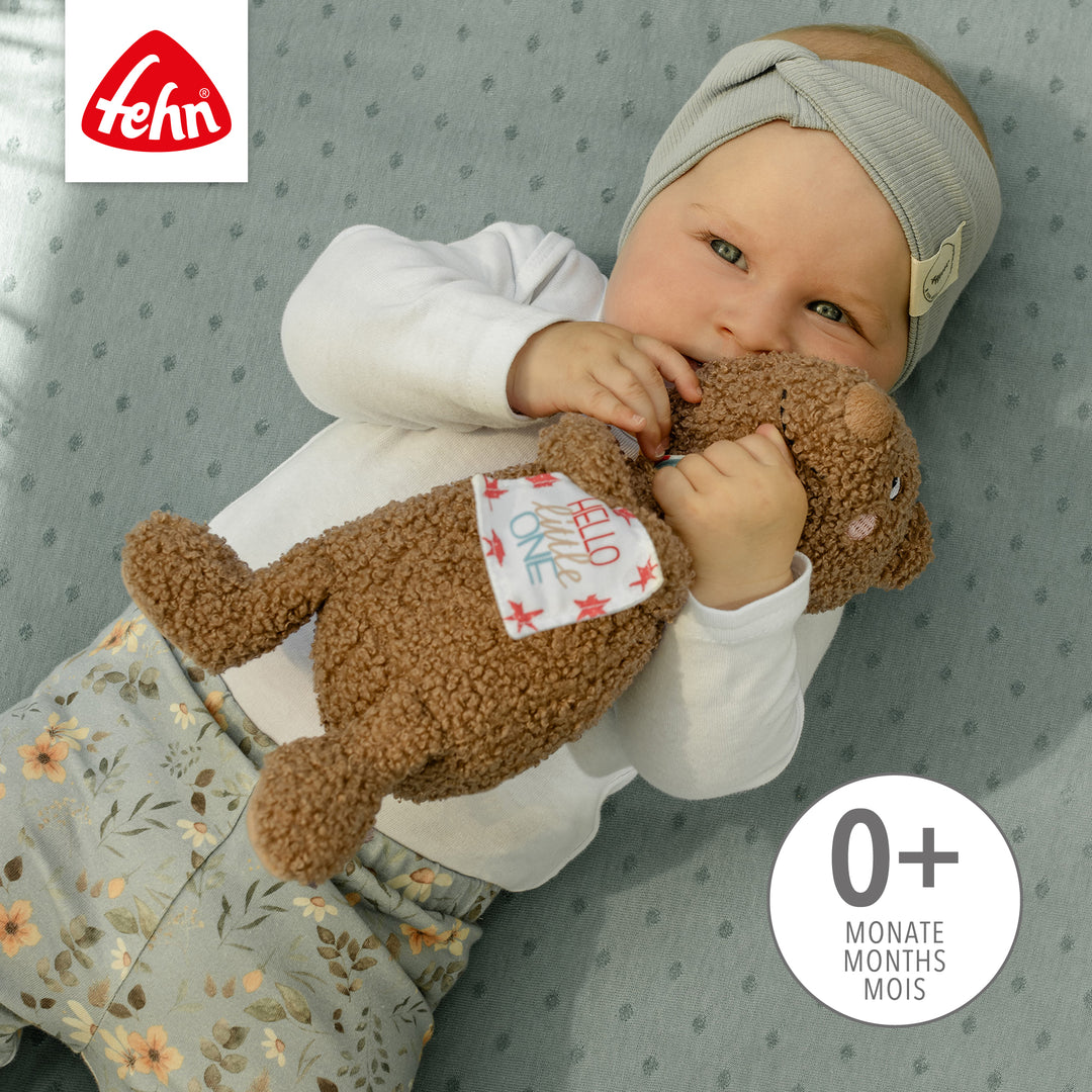 Baby spielt mit Baby Kuscheltier Bär
