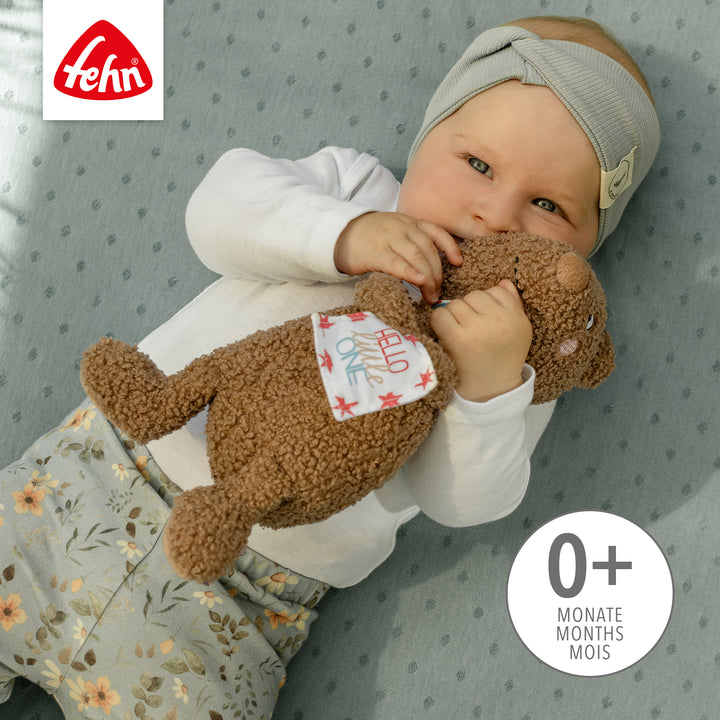 Baby spielt mit Baby Kuscheltier Bär