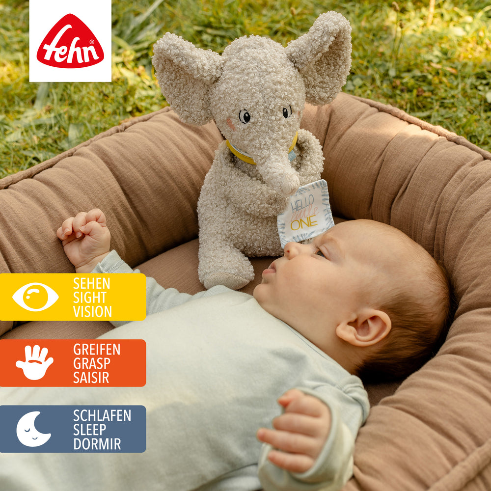 Baby liegt neben Baby Kuscheltier Elefant