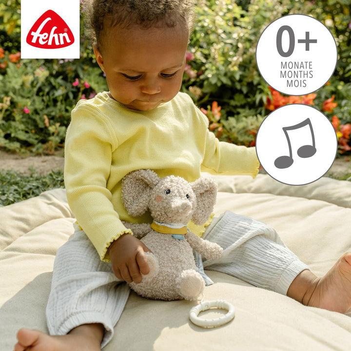 Baby spielt mit Baby Spieluhr Elefant