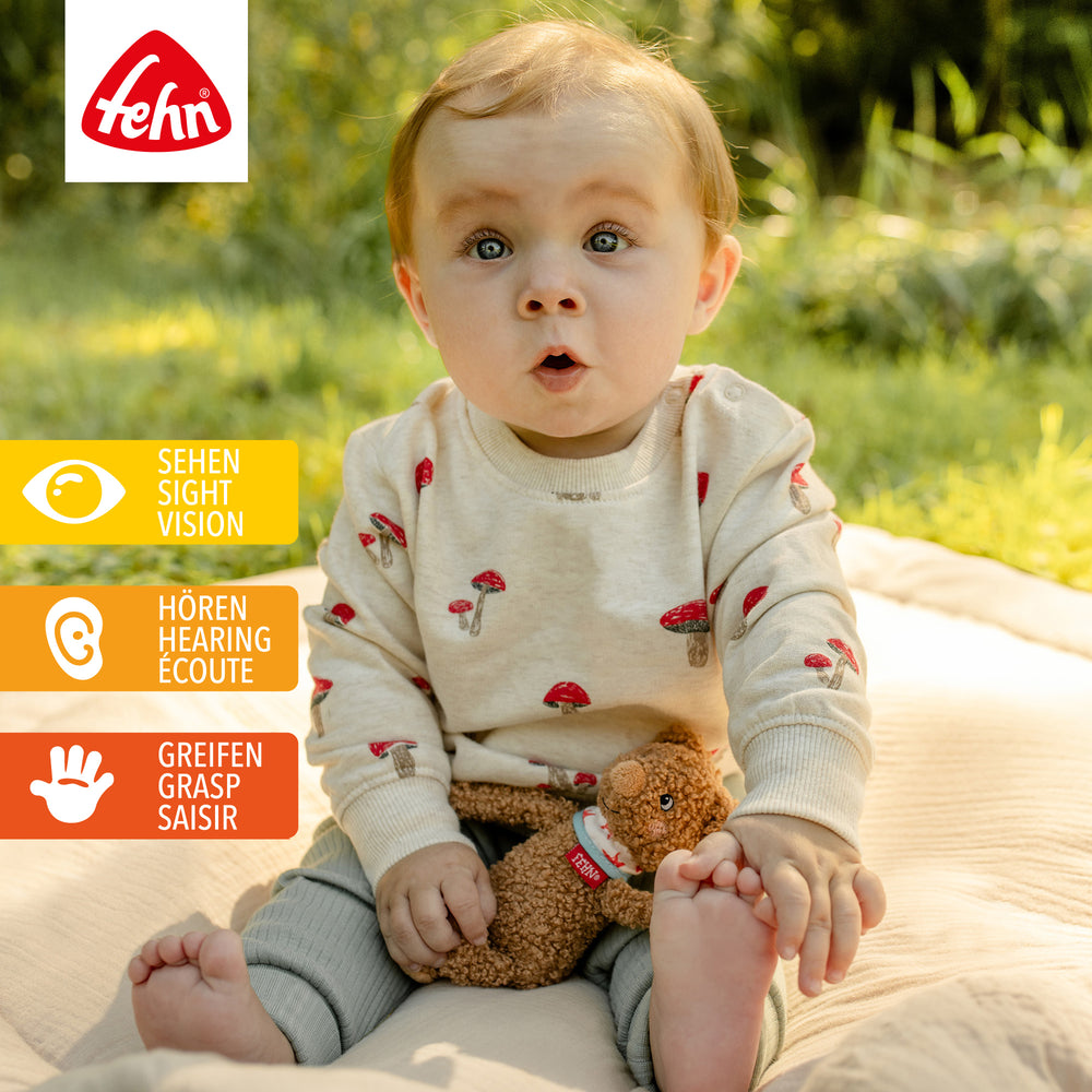 Baby spielt mit Baby Bean Bag Bär