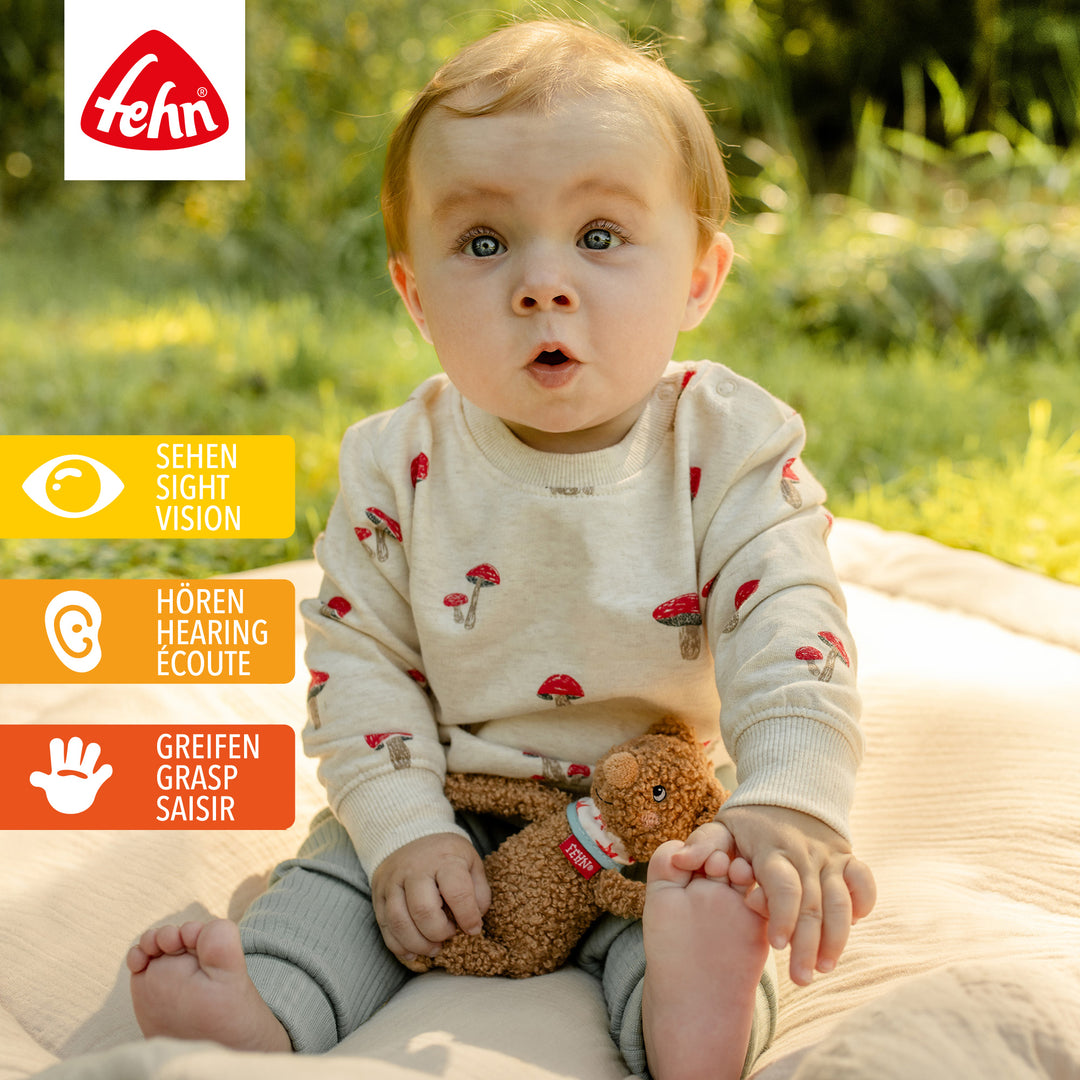 Baby spielt mit Baby Bean Bag Bär