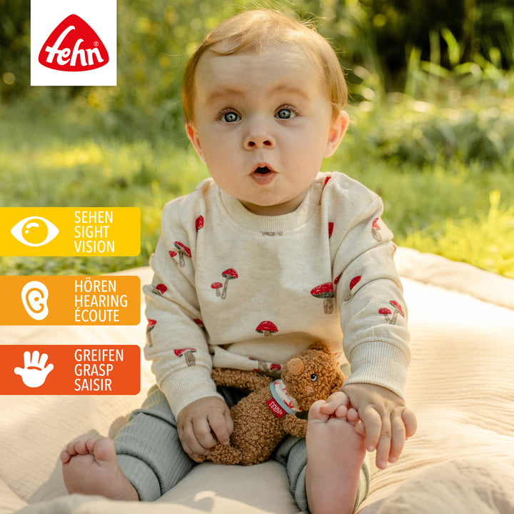 Baby spielt mit Baby Bean Bag Bär