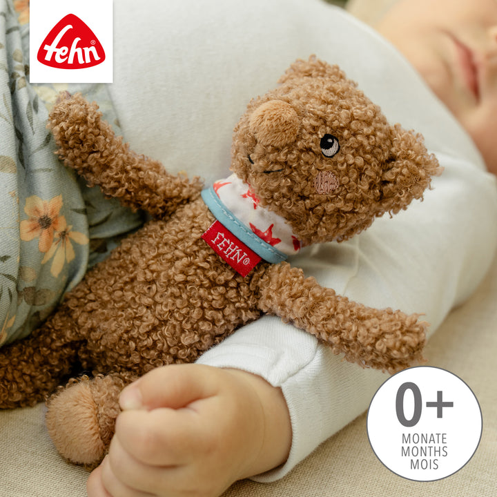 Baby hält Baby Bean Bag Bär im Arm