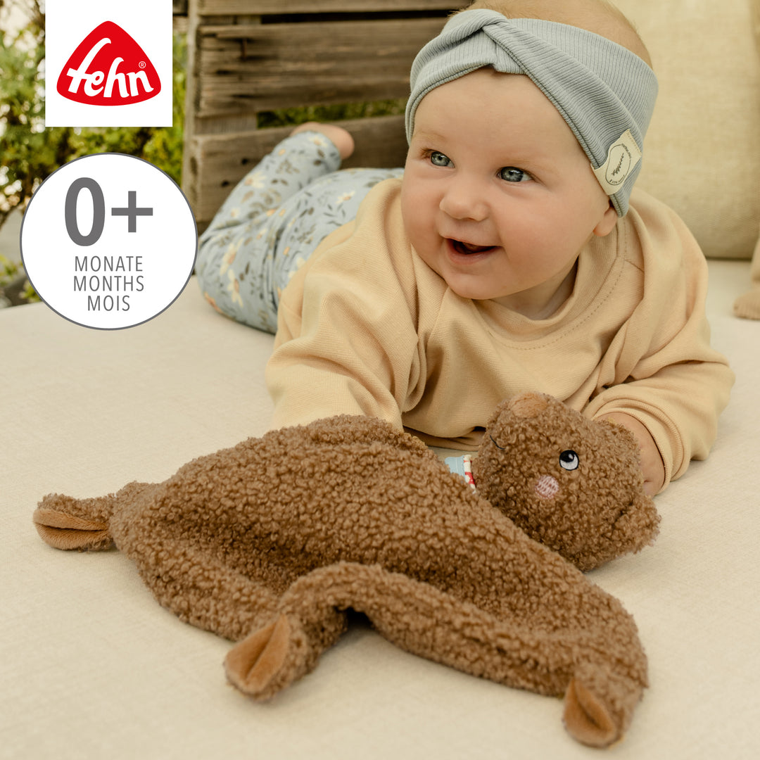 Baby spielt mit  Baby Schmusetuch Bär