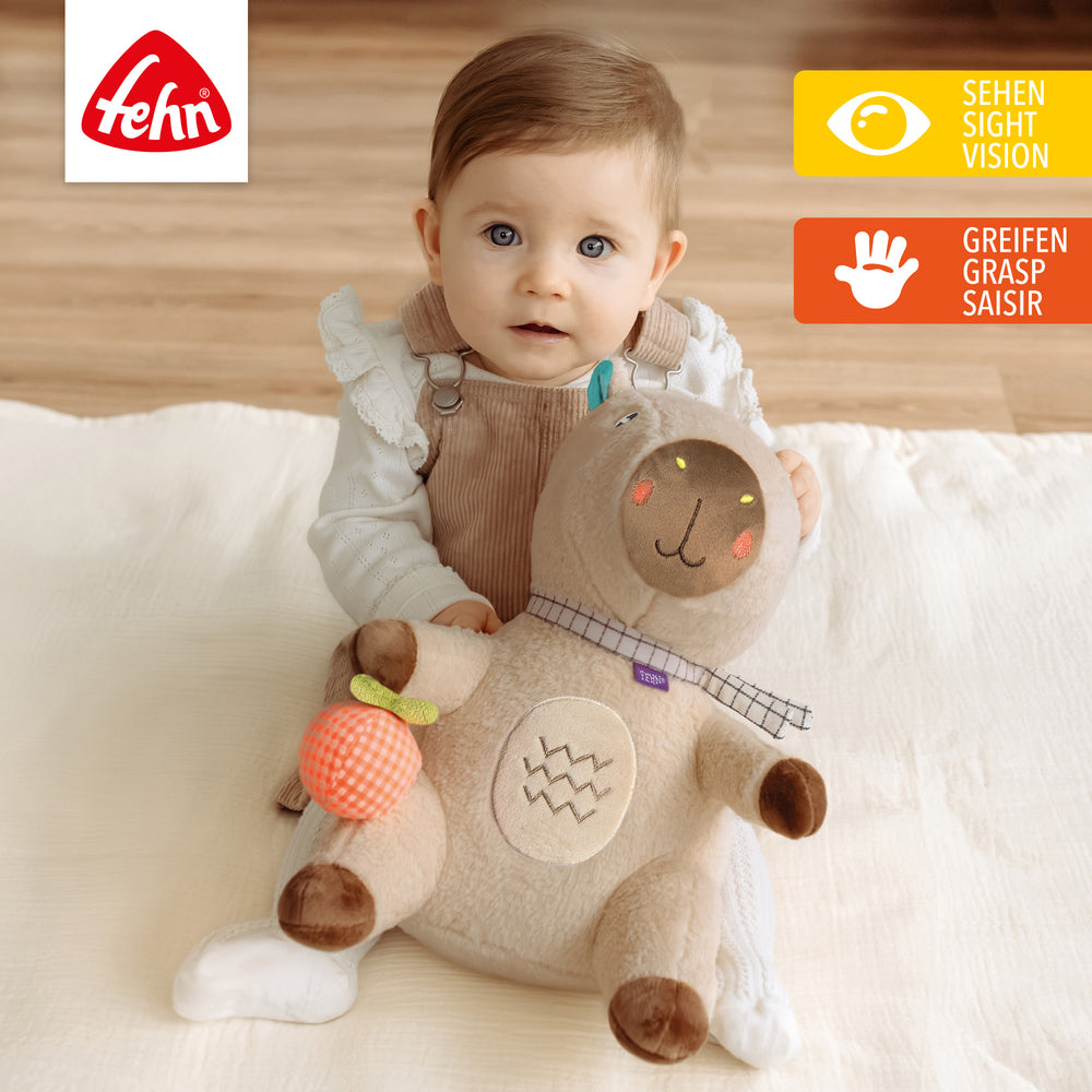 Baby spielt mit Baby Kuscheltier Capybara XL