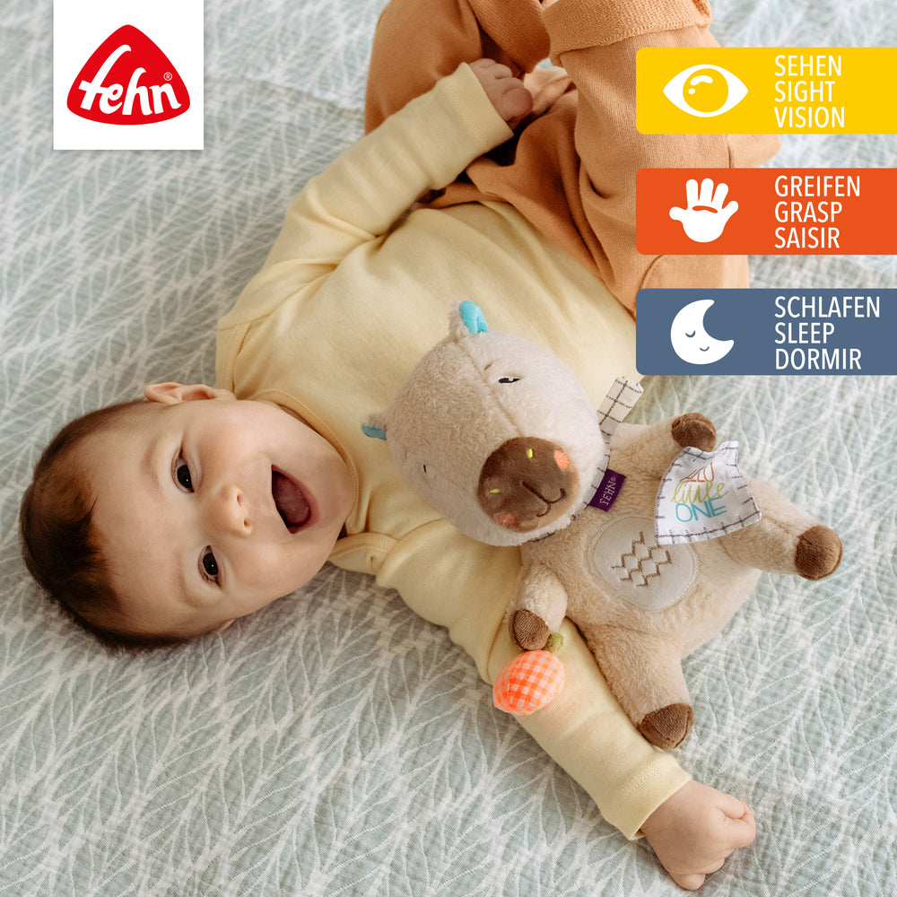 Baby spielt mit Baby Kuscheltier Capybara