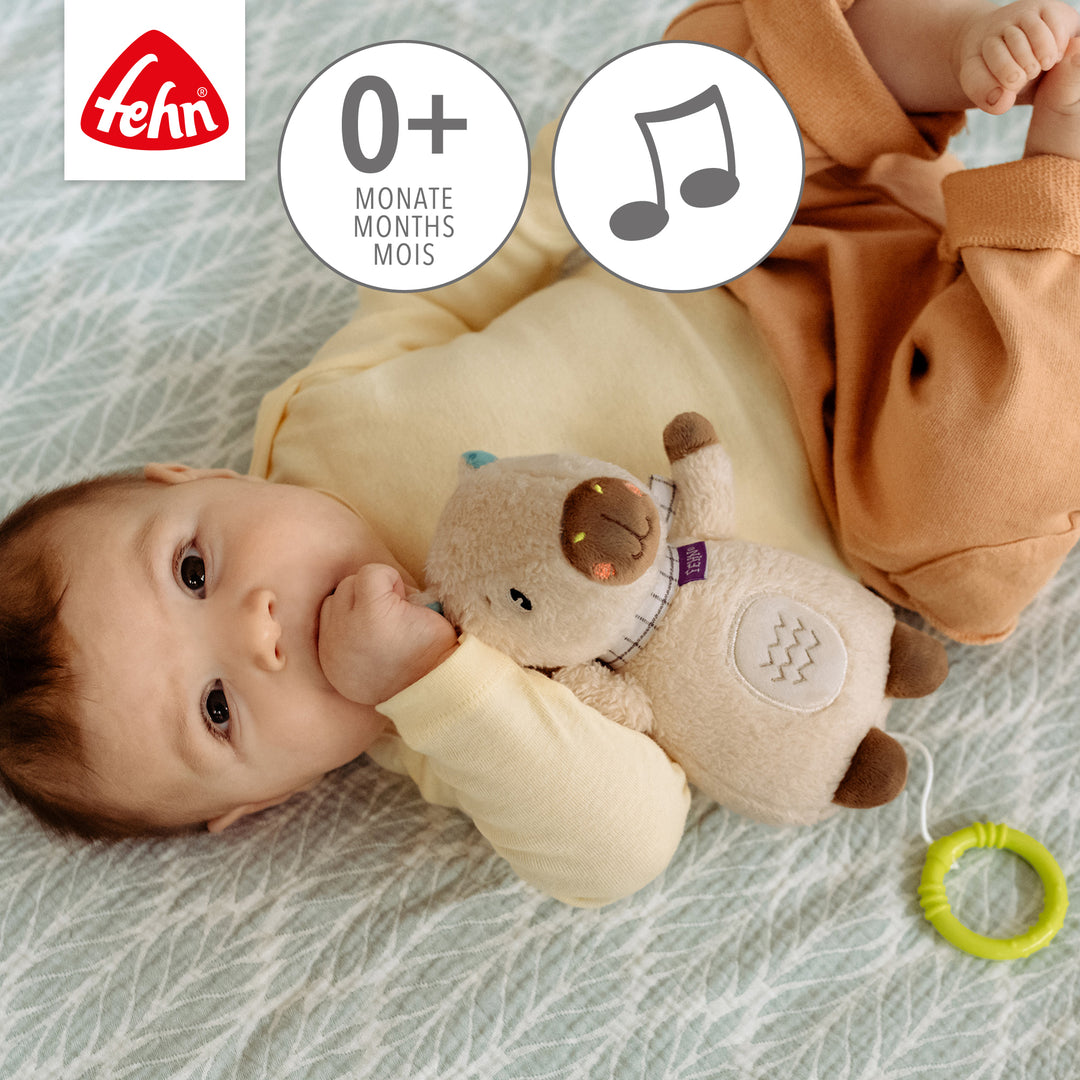 Baby spielt mit Baby Spieluhr Capybara