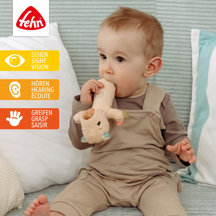 Baby spielt sitzend mit Baby Stabgreifling Capybara