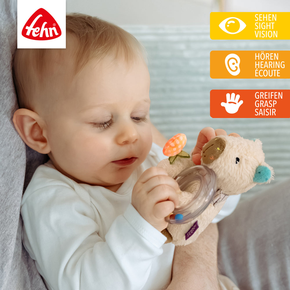 Baby spielt mit Baby Rasselring Capybara