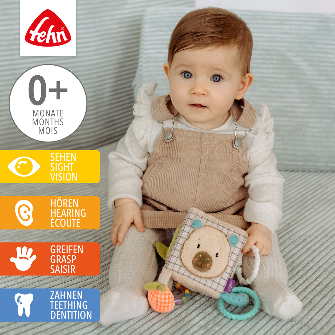 Baby spielt mit Baby Activity-Würfel Capybara aus weichem Plüsch