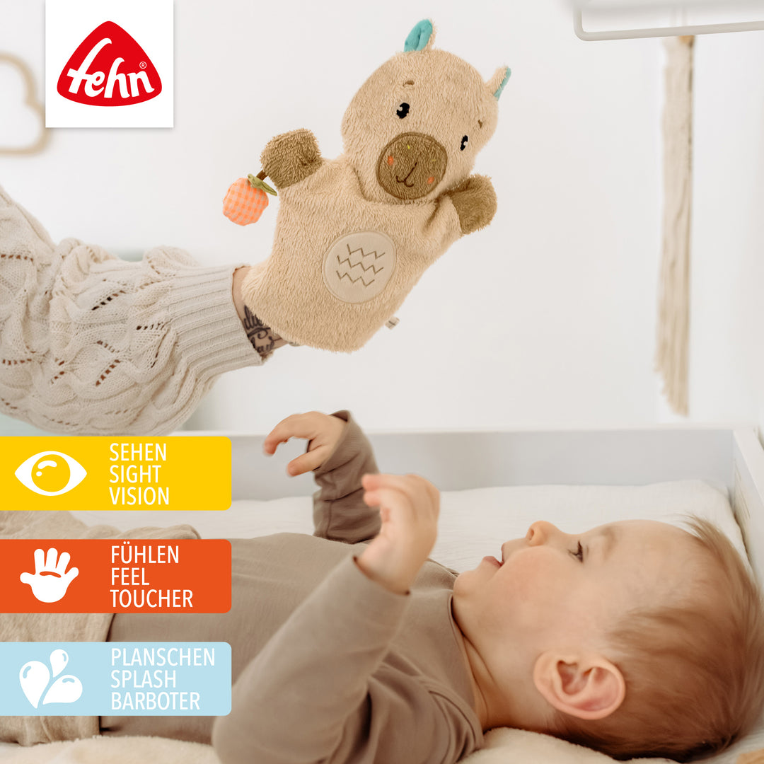 Baby greift nach Baby Wachhandschuh Capybara