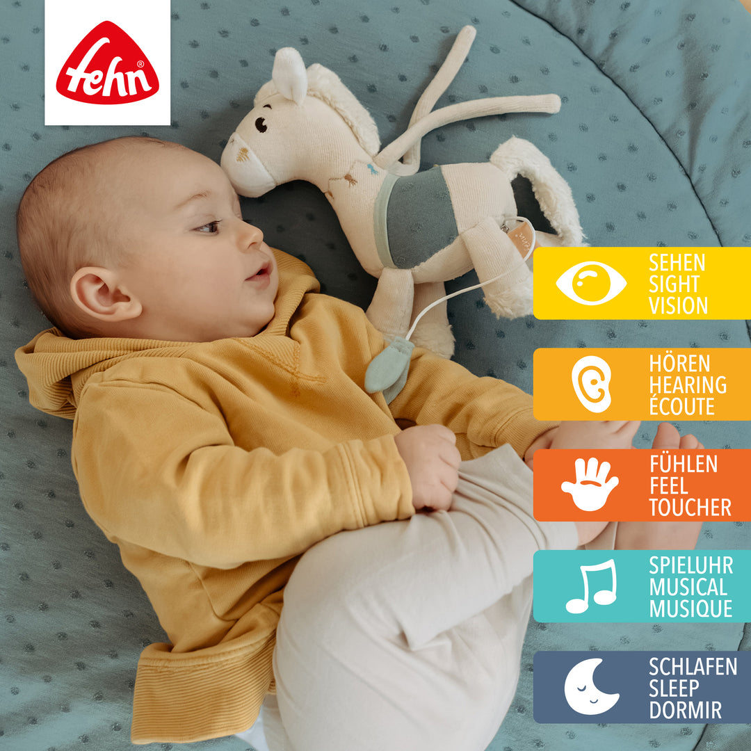 Baby spielt mit Baby Spieluhr Pferd