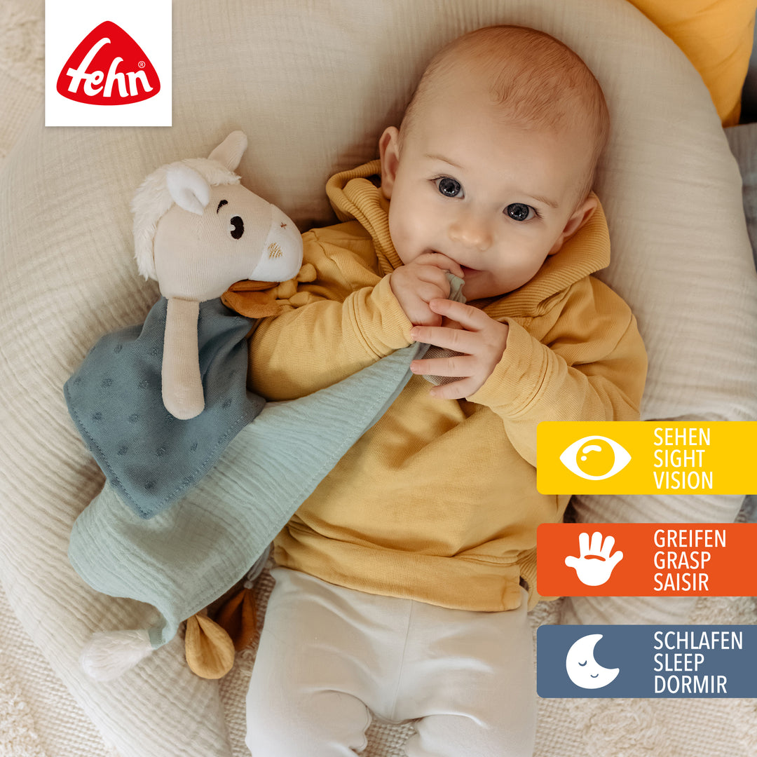 Baby spielt mit Baumwoll-Schmusetuch Pferd