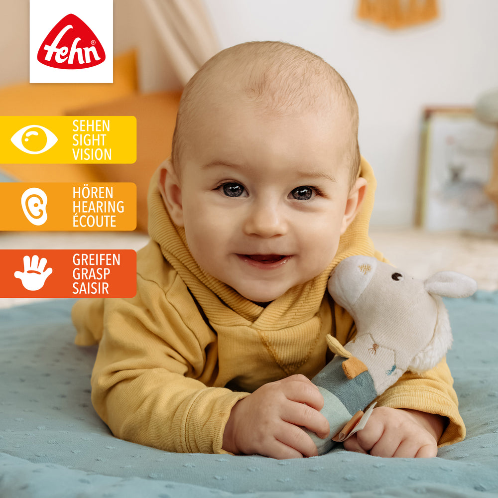 Baby spielt mit Baumwoll-Stabgreifling Pferd