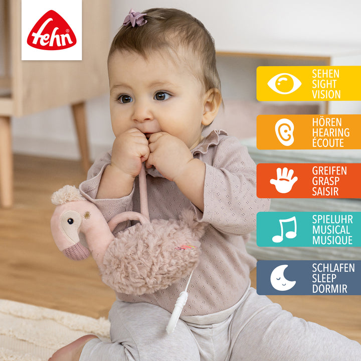Baby spielt mit Baby Spieluhr Flamingo