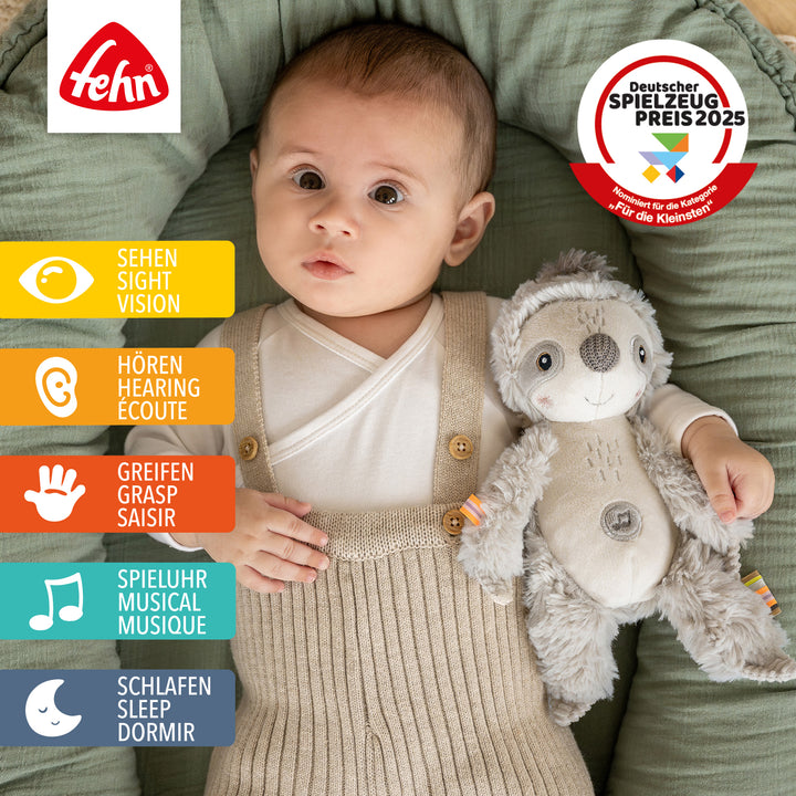 Baby liegt mit Baby Einschlafhilfe Faultier im Babybett
