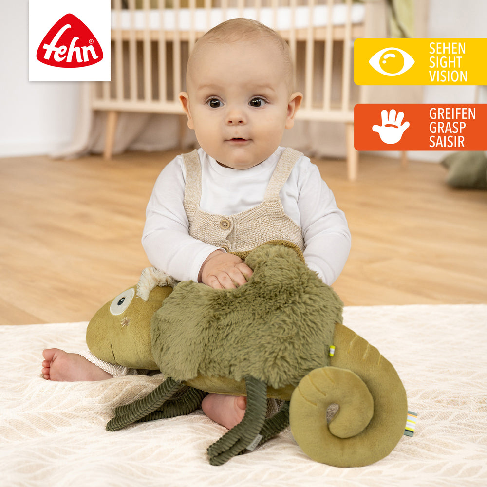 Baby spielt mit Baby Kuscheltier Chamäleon XL