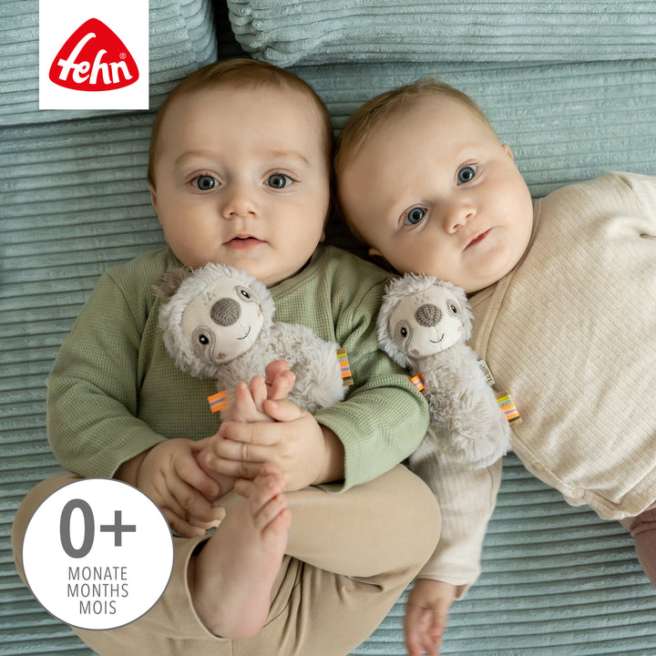 Babys spielen mit Baby Stabgreifling Faultier