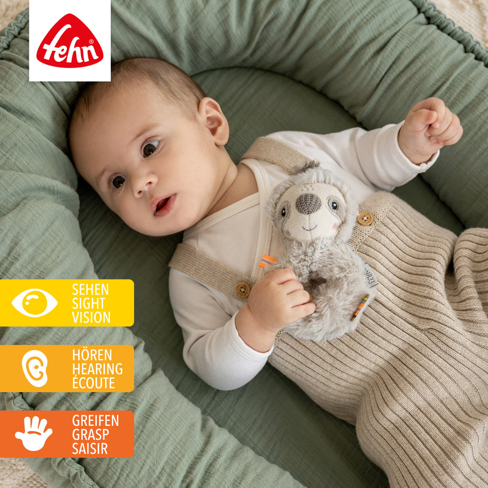 Baby hält Plüsch-Ring-Greifling Faultier