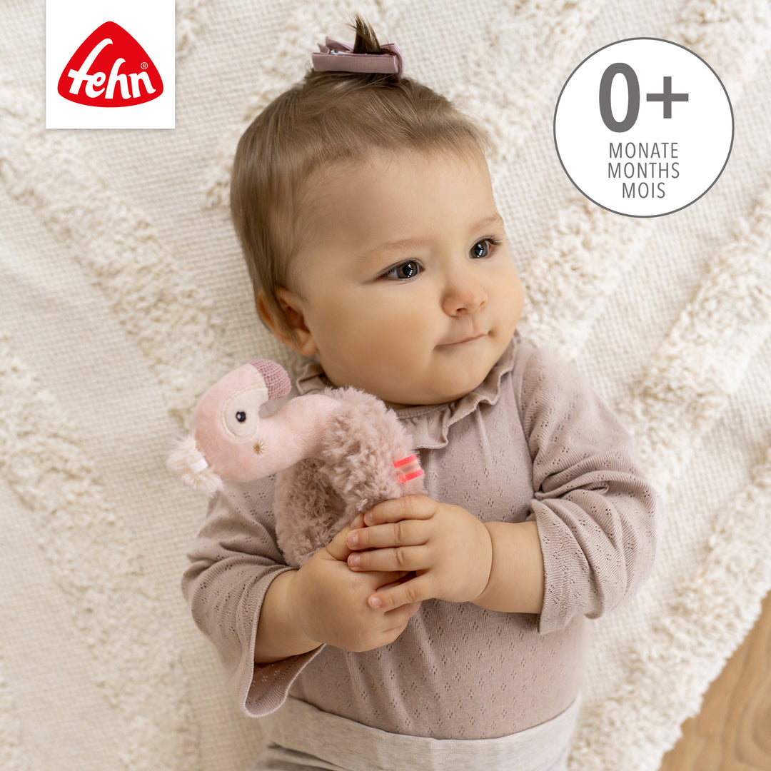 Baby hält Baby Ring-Greifling Flamingo
