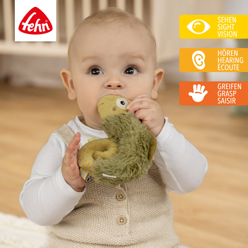 Baby spielt mit Plüsch-Ring-Greifling Chamäleon