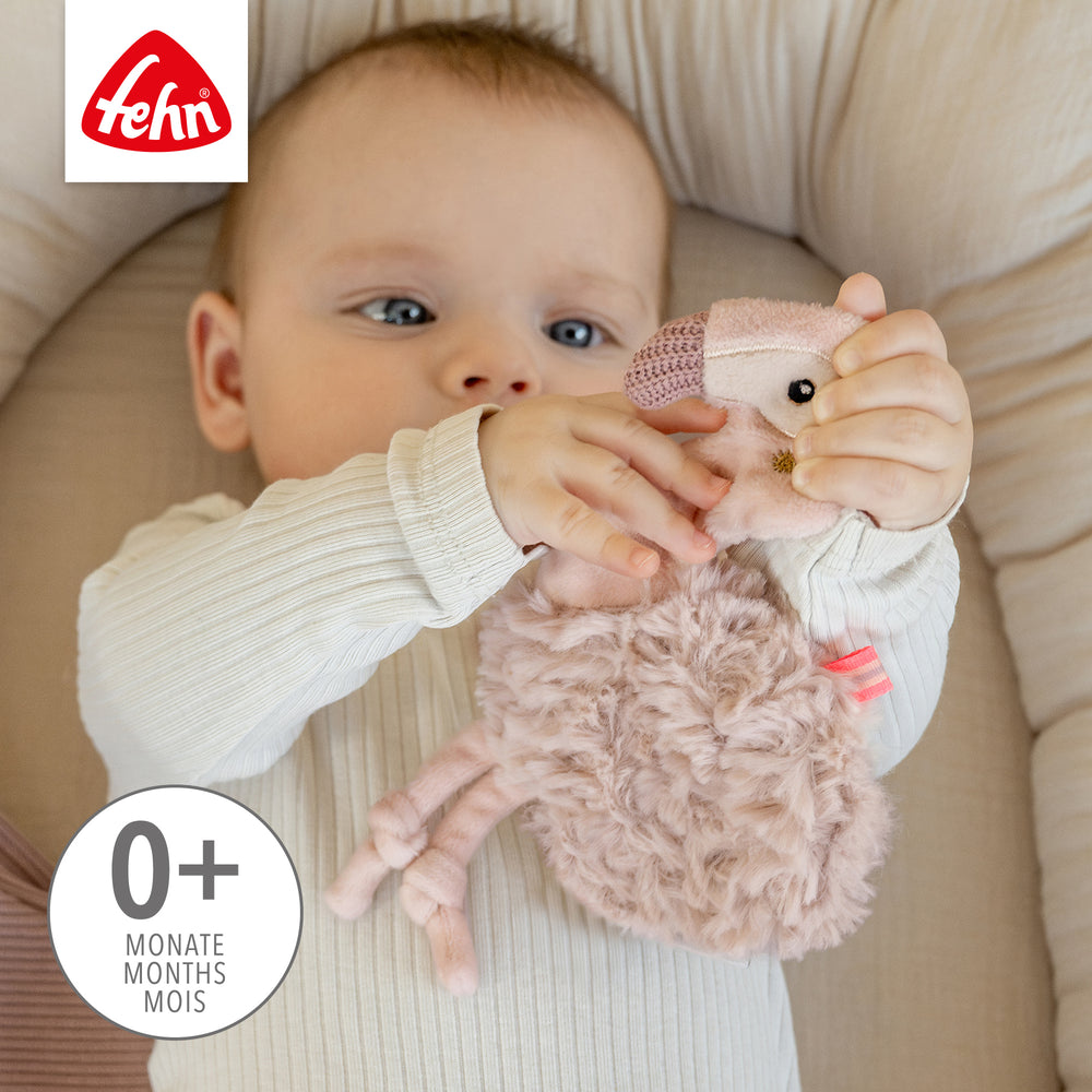 Baby spielt mit Baby Knister-Flamingo
