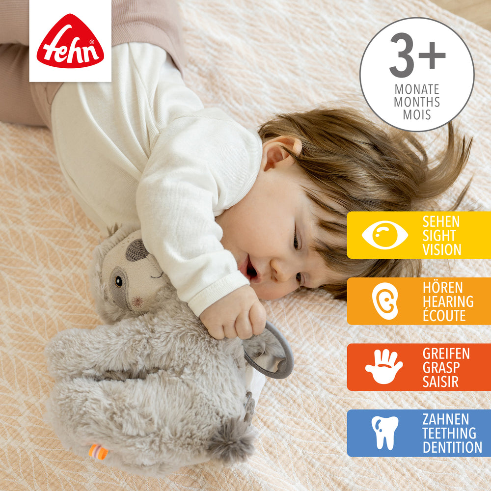 Baby spielt mit Baby Activity-Faultier aus weichem Plüsch