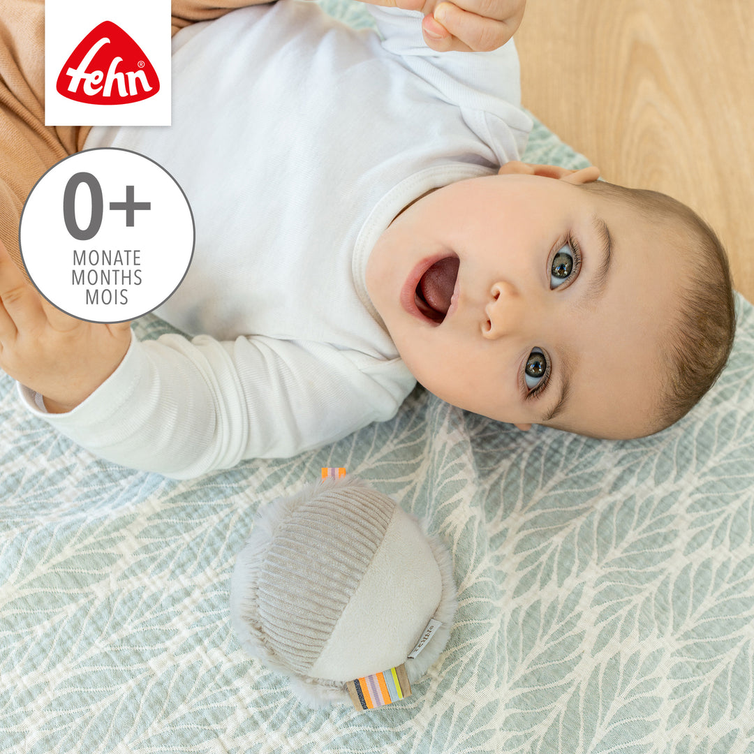 Baby spielt mit Baby Stoffball Faultier