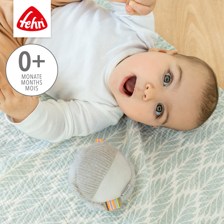 Baby spielt mit Baby Stoffball Faultier