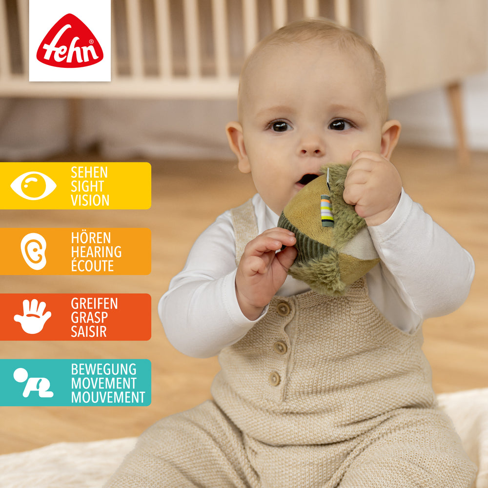 Baby spielt mit Plüsch-Stoffball Chamäleon