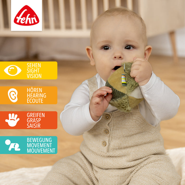 Baby spielt mit Plüsch-Stoffball Chamäleon
