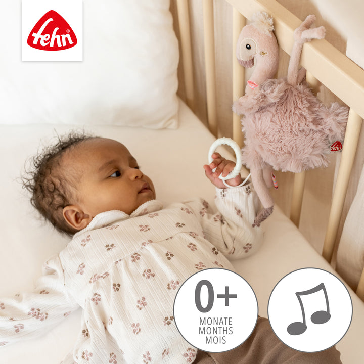 Baby spielt mit Baby Spieluhr Flamingo