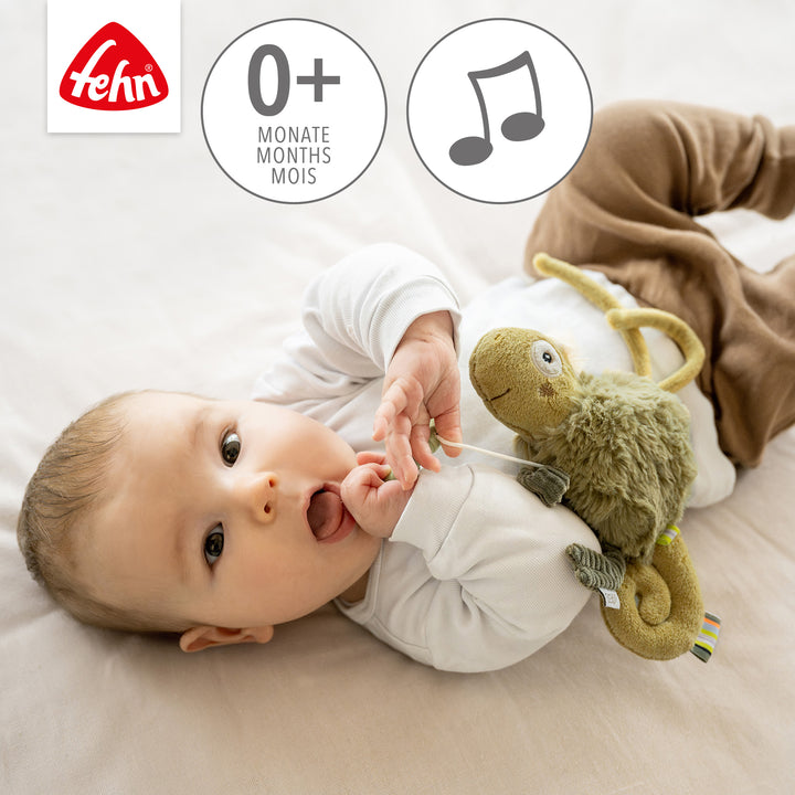 Baby spielt mit Baby Spieluhr Chamäleon