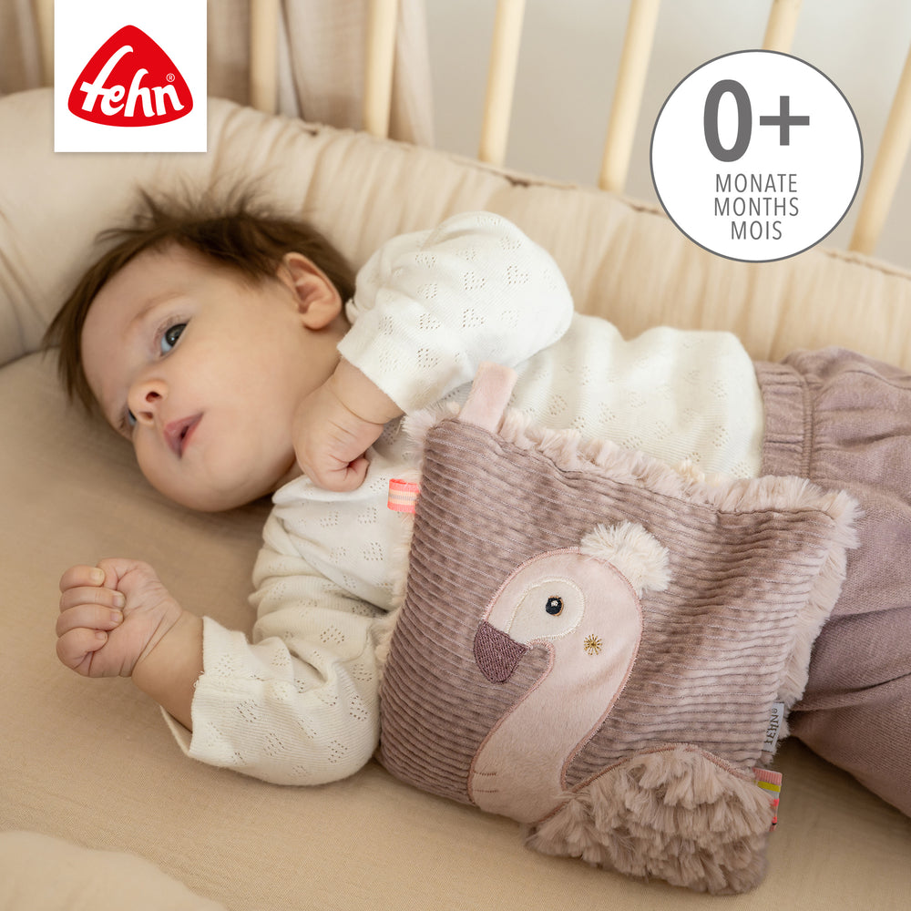 Baby kuschelt mit Baby Kirschkernkissen Flamingo aus weichem Plüsch