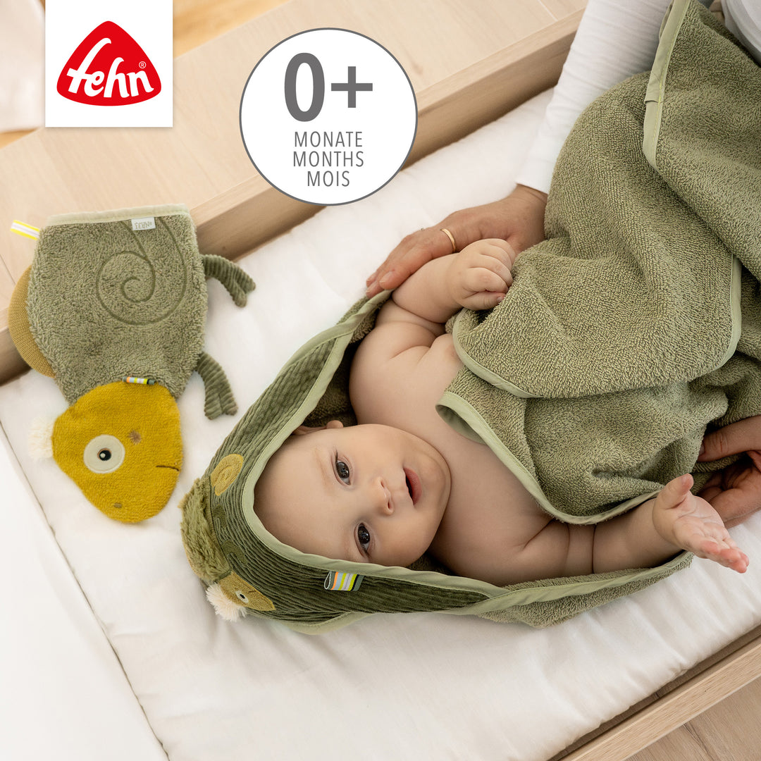 Baby greift nach Baby Waschhandschuh Chamäleon