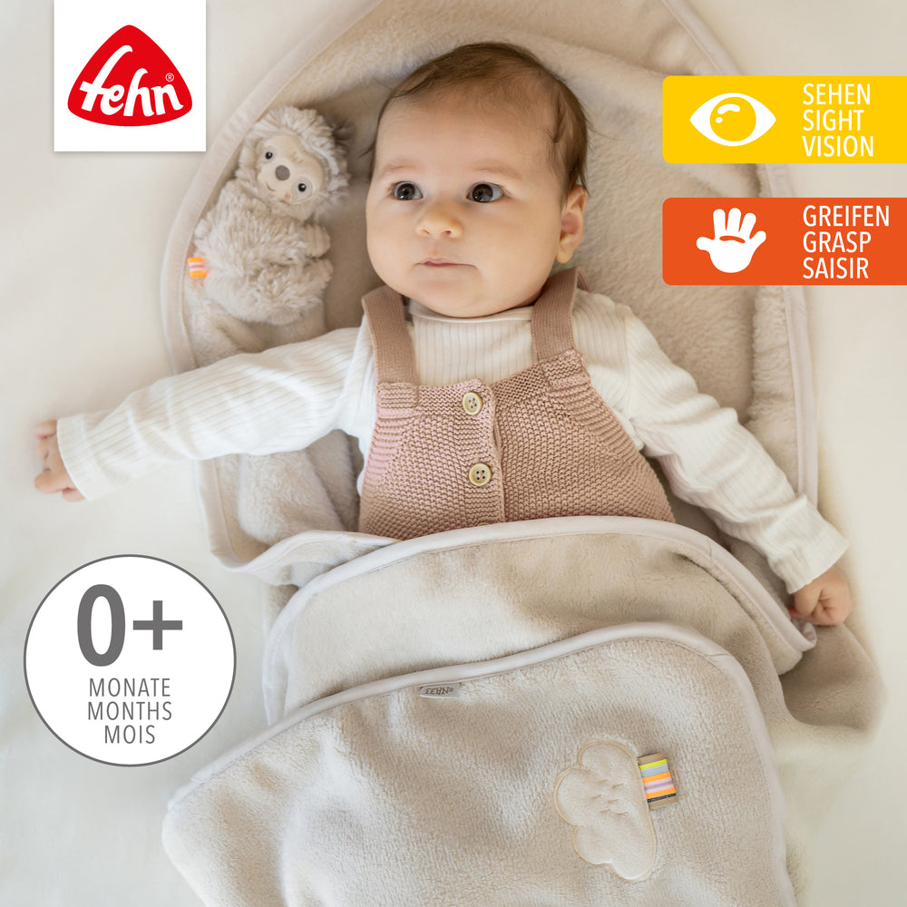 Baby liegt in Baby Kuscheldecke Faultier