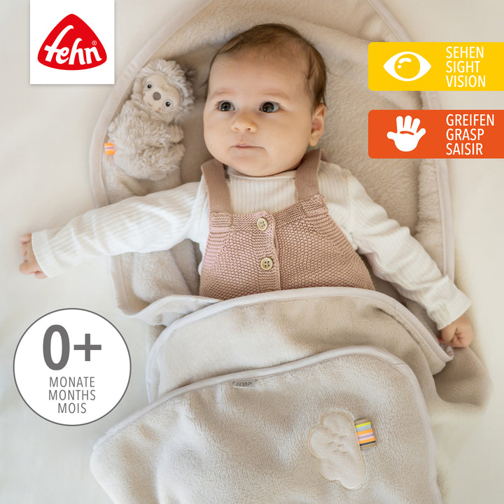 Baby liegt in Baby Kuscheldecke Faultier