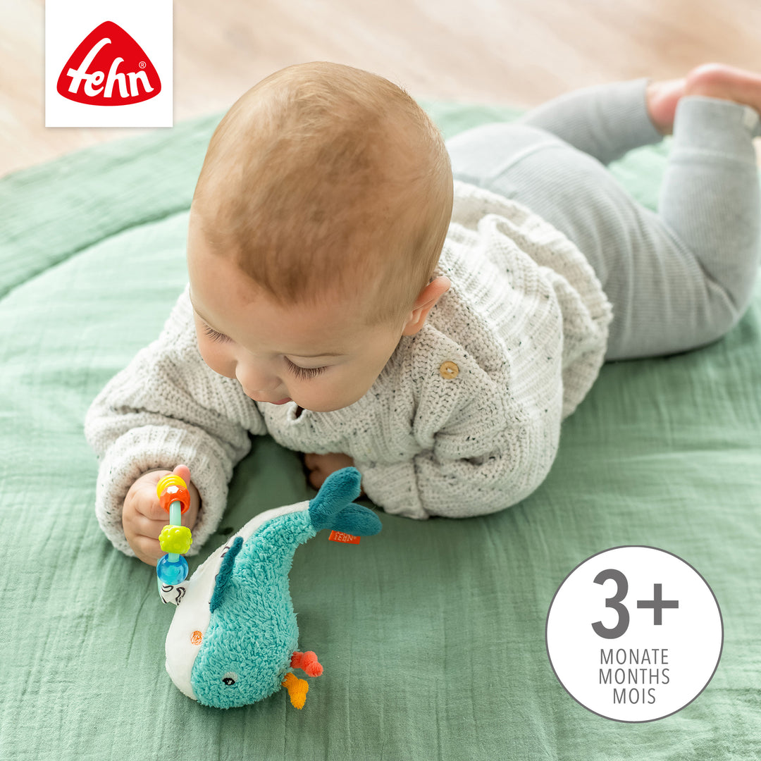 Baby greift nach Baby Perlenring Wal