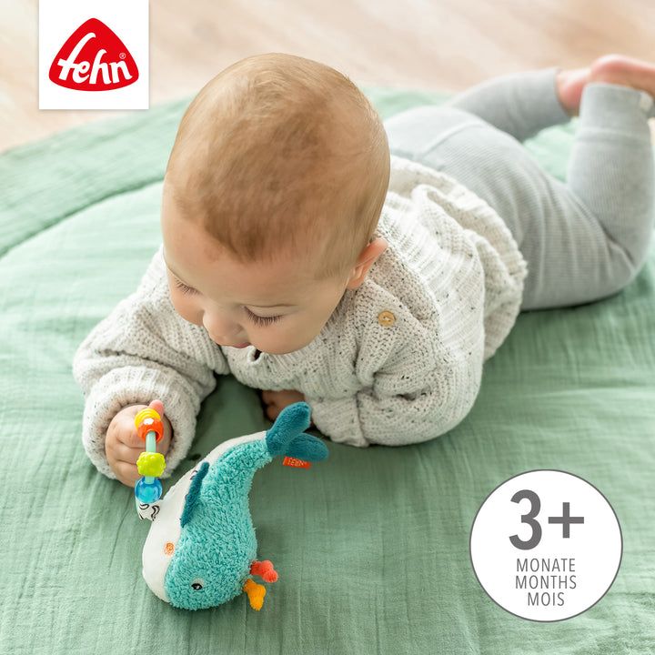 Baby greift nach Baby Perlenring Wal