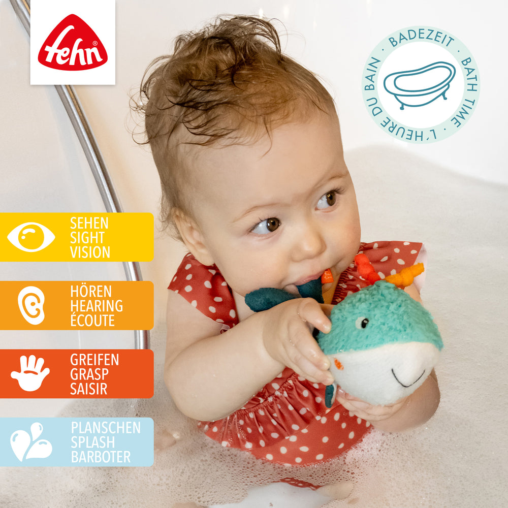 Baby spielt mit Baby Badetier Wal in der Badewanne