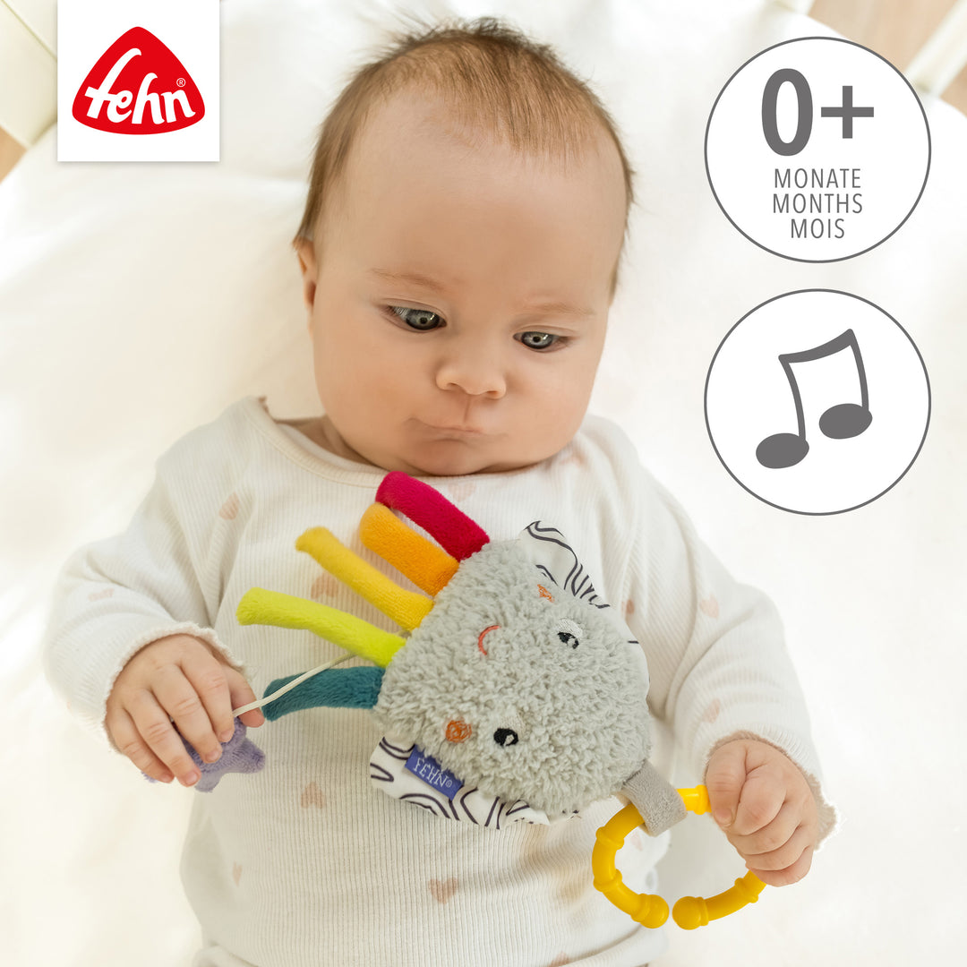 Baby spielt liegend mit Baby Spieluhr Tintenfisch