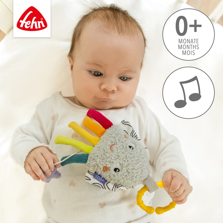 Baby spielt liegend mit Baby Spieluhr Tintenfisch