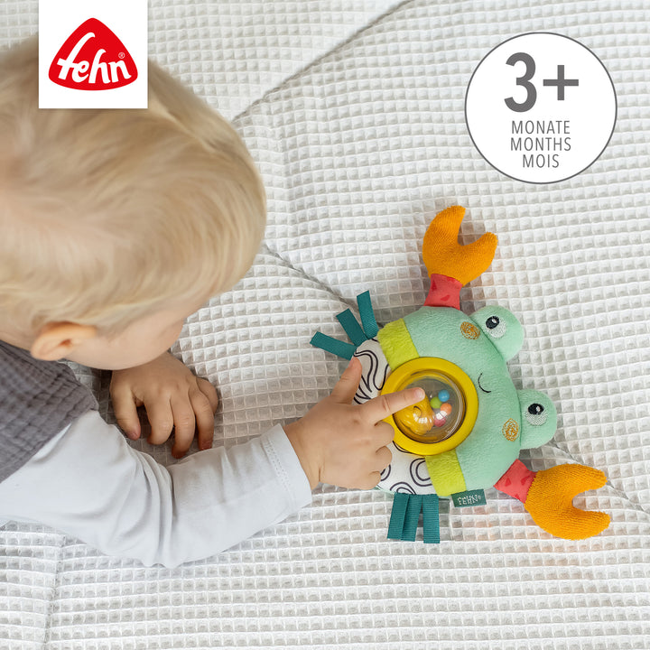 Baby greift nach Baby Drehballrassel Krabbe