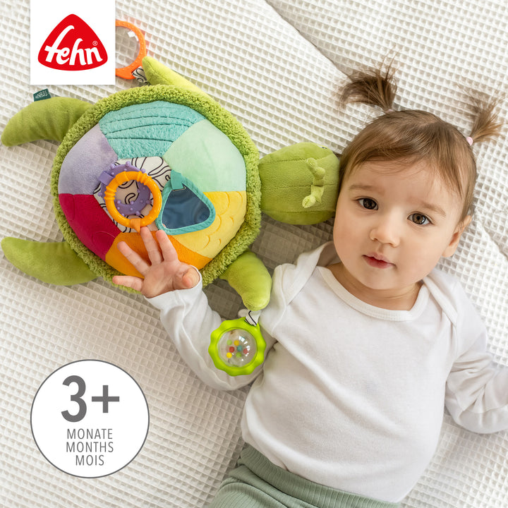 Baby greift nach Baby Activity-Meeresschildkröte XL