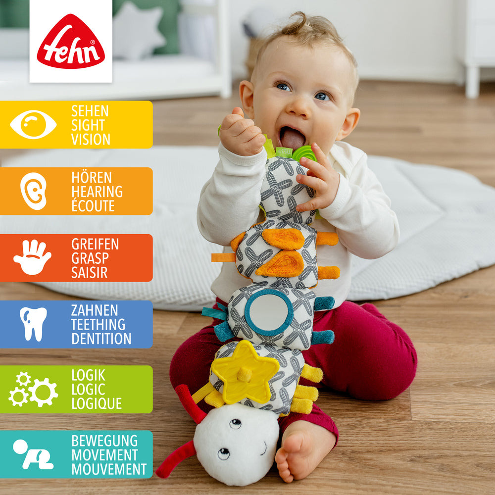 Baby spielt mit Baby Activity-Raupe aus weichem Plüsch