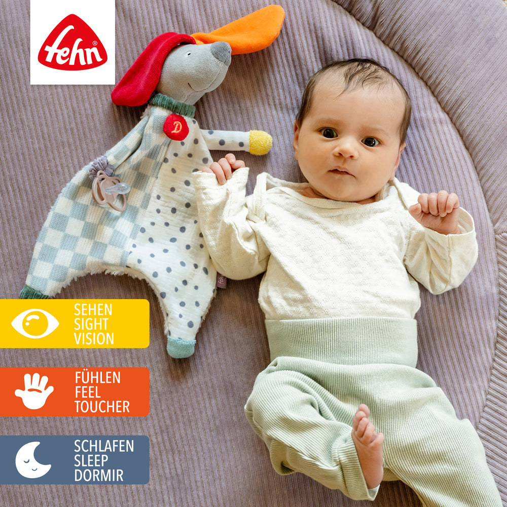 Baby spielt mit Baumwoll-Schmusetuch Hund