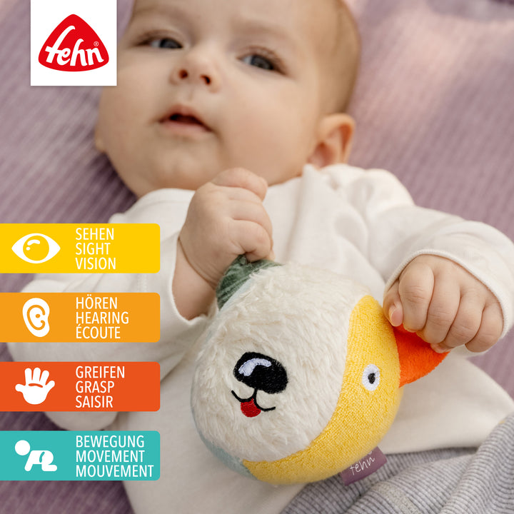 Baby spielt mit Baumwoll-Stoffball Hund
